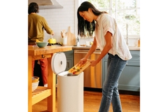 Image Woman disposing food in a bin.
